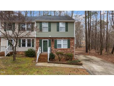 Charming townhome with brick accents, green shutters, and a well-maintained front yard at 402 Shannonford Ct, Wake Forest, NC 27587