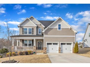 Charming two-story home with a welcoming front porch, stone accents, and a two-car garage at 525 Marion Hills Way, Knightdale, NC 27545