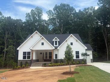 Charming two-story home featuring white siding, stone accents, and a well-manicured front lawn at 60 Valebrook Ct, Youngsville, NC 27596