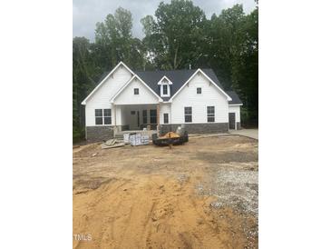 Charming new construction home with white siding and stone accents on a spacious lot at 60 Valebrook Ct, Youngsville, NC 27596