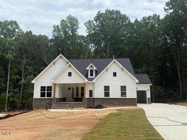 Beautiful two-story home with white siding, stone accents, and a lush green lawn at 60 Valebrook Ct, Youngsville, NC 27596