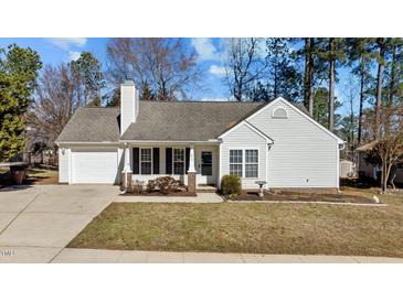 Charming single-story home with white siding, well-maintained lawn, and attached garage at 613 Flaherty Ave, Wake Forest, NC 27587