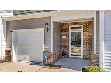 Inviting front door with brick detail, garage, and security system at 123 Liam St, Clayton, NC 27520