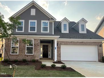 Beautiful two-story home featuring a brick and siding exterior, attached two car garage and landscaped front yard at 124 Willow Cameron Way, Angier, NC 27501