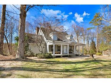 Charming white two-story home with a full front porch and mature trees in a large yard at 12808 Old Stage Rd, Willow Springs, NC 27592