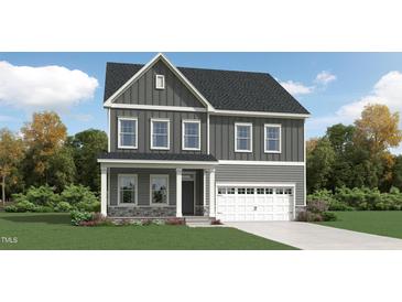 Charming two-story home with a covered porch and attached two-car garage, complemented by a beautifully landscaped front yard at 1308 Hazelnut Ridge Ln, Knightdale, NC 27545