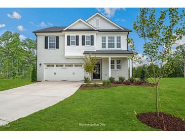 Charming two-story home with a manicured lawn, brick accents, and a spacious two-car garage at 20 Eagle Crest Court Way # Holly Farmhouse, Lillington, NC 27546