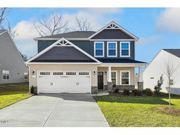 Charming two-story home featuring a two-car garage, manicured lawn, and craftsman-style details at 212 Wildwood Ln, Graham, NC 27253