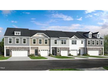 Charming townhome exteriors feature stone accents, neutral siding, and attached garages for a modern look at 270 Sweetbay Tree Dr, Wendell, NC 27591