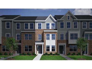 Charming three-story townhome with brick facade, light grey accents, and inviting front entrances at 324 Chesapeak Commons St # 143, Garner, NC 27529