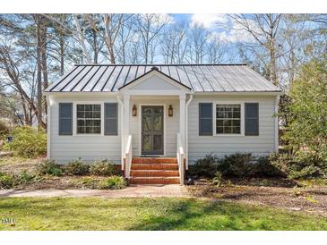 Charming home features a metal roof, painted brick stairs, and beautiful landscaping at 35 Rogerson Dr, Chapel Hill, NC 27517