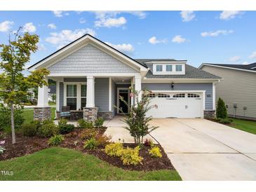 Charming home with a well-manicured lawn, a covered porch, and an attached two-car garage at 3528 Olive Glen Dr, Apex, NC 27502