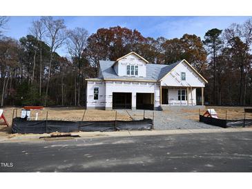 Exterior of a new build home, almost complete, featuring an attached two-car garage and covered front porch at 3821 Fairway View Dr # 11, Fuquay Varina, NC 27526