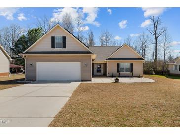 Charming single-story home featuring a two-car garage and manicured lawn at 66 Newbury Dr, Angier, NC 27501