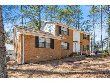 Traditional brick home featuring well-maintained landscaping and a welcoming front entrance with a wooden porch at 100 Forsyth Dr, Chapel Hill, NC 27517