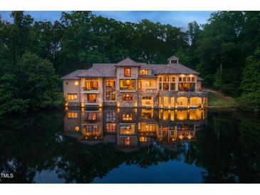Spectacular lakefront home boasts multiple levels, stone accents, and water access for luxurious living at 102 Anna Lake Ln, Cary, NC 27513