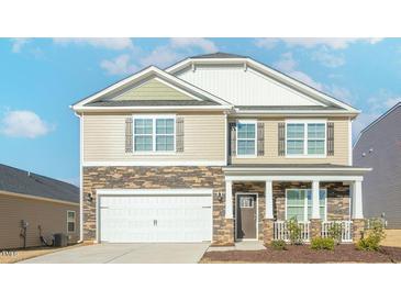 Charming two-story home featuring a stone and siding exterior with an attached two-car garage at 2561 Summersby Dr, Mebane, NC 27302