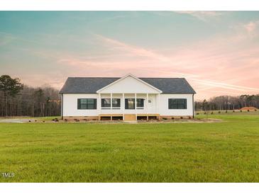 Charming single-story home featuring a welcoming front porch and classic black shutters at 29 Hinshaw Shop Rd, Liberty, NC 27298