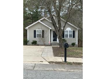 Charming single-story home featuring a well-maintained lawn, classic shutters, and a welcoming front entrance at 309 Gladstone Dr, Durham, NC 27703