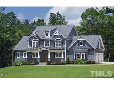 Beautiful two-story home with stylish blue siding, gabled roof, and a well-manicured front lawn at 405 Fieldstone Ln, Pittsboro, NC 27312