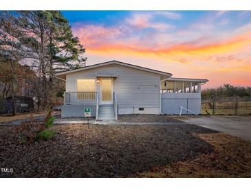 Charming one-story home featuring a covered porch and a partially screened patio addition at 409 S 13Th St, Lillington, NC 27546