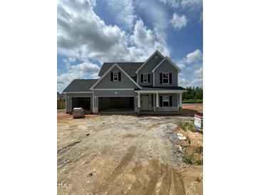 New construction home featuring gray siding, black shutters, and a three-car garage on a sunny day at 432 E Clydes Point Way, Wendell, NC 27591