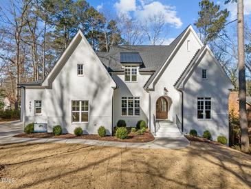 Stunning white brick home featuring a well-manicured lawn and professionally landscaped shrubbery at 4501 Bartlett Dr, Raleigh, NC 27609