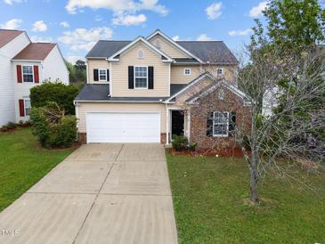 Charming two-story home with a well-manicured lawn, attached garage, and brick facade accent at 6013 Shelane Ct, Raleigh, NC 27610