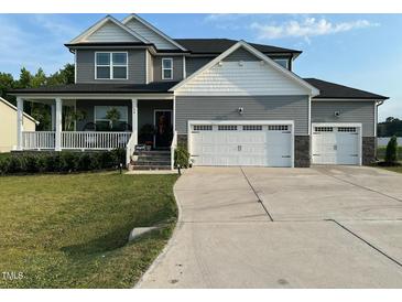 Beautiful two-story home with a three car garage, and welcoming front porch with gray vinyl siding at 94 Aylebury Rdg, Zebulon, NC 27597