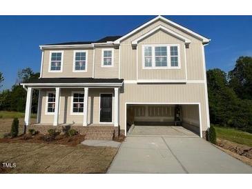 Charming two-story home with an attached two-car garage and inviting front porch at 119 Grove Township Way, Angier, NC 27501