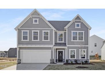 Charming two-story home with a classic design, showcasing a well-manicured lawn and an attached two-car garage at 185 Horseshoe Pl # 54, Angier, NC 27501