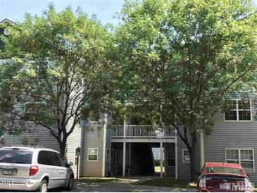 Two-story building exterior with balcony access in between, covered by trees and parked cars in front at 1911 Wolftech Ln # 303, Raleigh, NC 27603