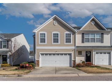 Inviting two-story home featuring a two-car garage and manicured landscaping at 1952 Grassy Banks Dr, Raleigh, NC 27610