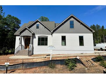 Charming home with a combination of painted brick and vinyl siding, set against a backdrop of lush greenery at 55 Cherry Bark Dr, Youngsville, NC 27596
