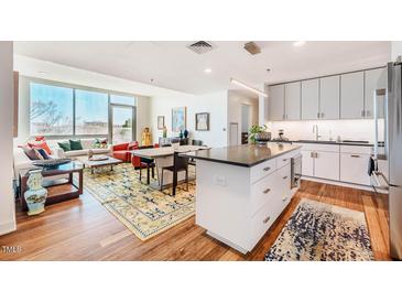 Bright open living room with a kitchen island, natural light, and stylish decor at 601 W Rosemary St # 403, Chapel Hill, NC 27516