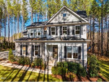 Charming two-story home with stone accents, well-manicured landscaping, and black shutters at 749 Bowden Rd, Chapel Hill, NC 27516