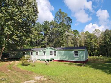Charming single-story home featuring a painted exterior, white trim, a small deck, and a green lawn at 88 Barnes Rd, Middlesex, NC 27557