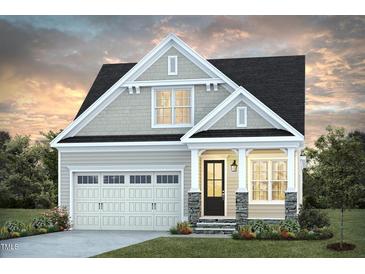 Charming two-story home featuring a black roof, stone accents, manicured lawn, and an attached garage at 101 Big Bradley Dr, Wendell, NC 27591