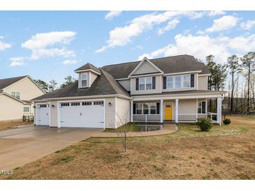 Charming home featuring a three car garage, and a welcoming front porch at 104 Coats Ridge Dr, Benson, NC 27504