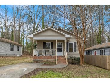 Charming home featuring a cozy front porch with brick accents and mature trees at 2513 Drexall Ave, Durham, NC 27704