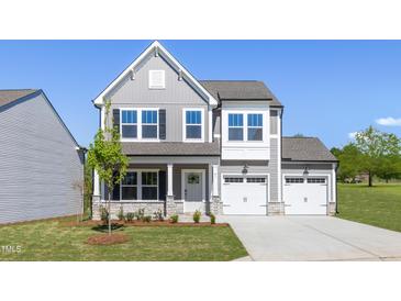 Charming two-story home featuring gray siding, a two-car garage, and a well-manicured front lawn at 41 Silver Moon Ln # 115, Clayton, NC 27527