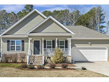 Charming single Gathering home featuring a cozy porch and well-maintained landscaping at 457 Cokesbury Park Ln, Fuquay Varina, NC 27526