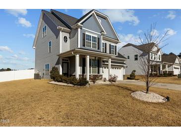 Charming two-story home featuring a manicured lawn and a welcoming front porch with stately white columns at 5601 Garnet Meadow Rd, Knightdale, NC 27545