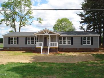 Charming ranch-style home featuring gray siding, black shutters, and a welcoming front porch at 5780 Plain View Hwy, Dunn, NC 28334