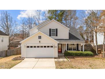 Charming two-story home with a two-car garage and well-manicured landscaping at 613 Holly Thorn Trce, Holly Springs, NC 27540