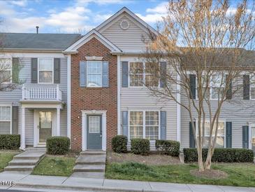 Charming townhome exterior with brick accents, manicured lawn, and inviting entry steps at 706 Canyon Lake Cir, Morrisville, NC 27560
