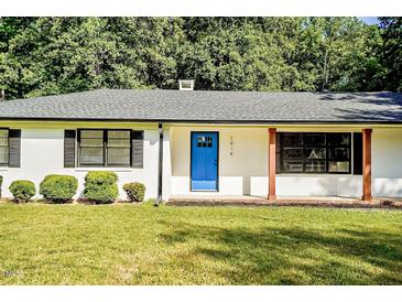 Charming home featuring a bright blue front door, black shutters, and well-maintained landscaping at 7414 Virgilina Rd, Roxboro, NC 27574