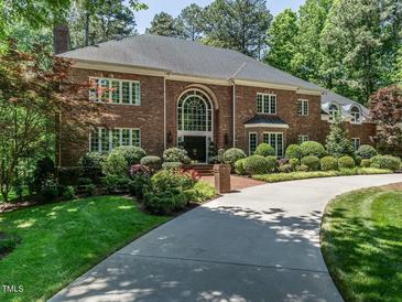 Elegant brick home with a well-manicured lawn and a circular driveway, creating a welcoming curb appeal at 107 Marseille Pl, Cary, NC 27511
