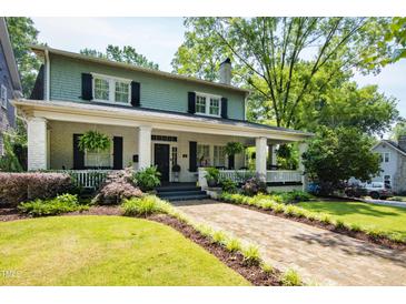 Charming two-story home with a brick walkway, covered front porch and manicured landscaping at 1200 Glenwood Ave, Raleigh, NC 27605