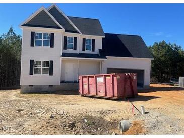 Charming two-story home with attached garage, black roof, and an empty lot at 122 Reece Dr, Sanford, NC 27332